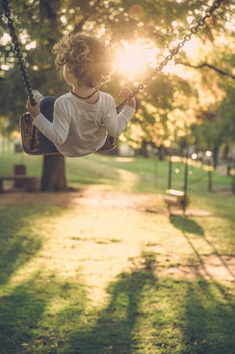 A child on a swing in warm evening light